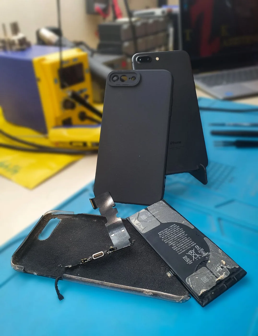 iPhone 8 Plus após reparo, com componentes substituídos sobre a bancada